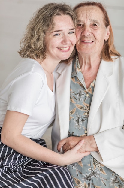 Retrato de mujer sonriente con su abuelita mirando a cámara