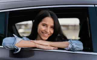 Foto gratuita retrato de mujer sonriente en su coche