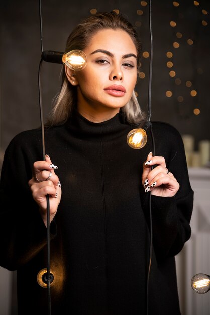 Retrato de mujer sonriente en suéter negro de pie y posando.