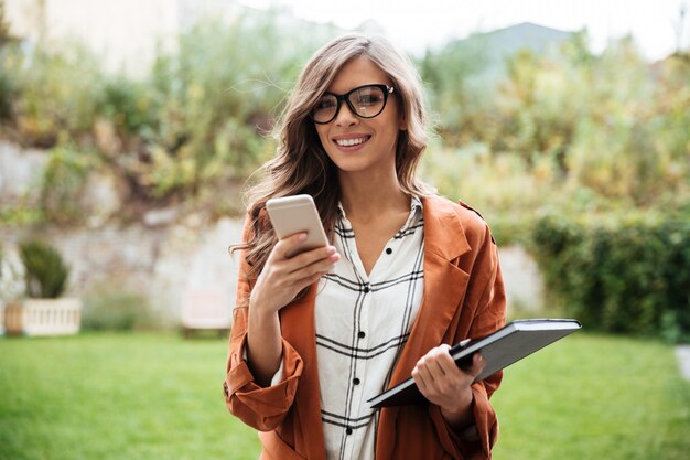 Retrato de una mujer sonriente con teléfono móvil