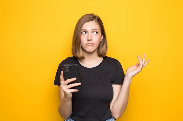 Retrato de mujer sonriente con teléfono sosteniendo smartphone y mirando hacia atrás