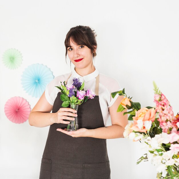 Foto gratuita retrato, de, un, mujer sonriente, tenencia, florero