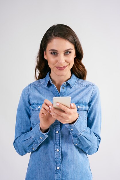 Retrato, de, mujer sonriente, tenencia, teléfono móvil