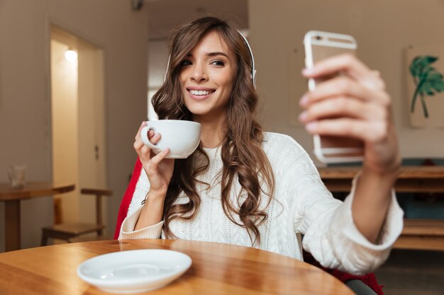 Retrato de una mujer sonriente tomando un selfie