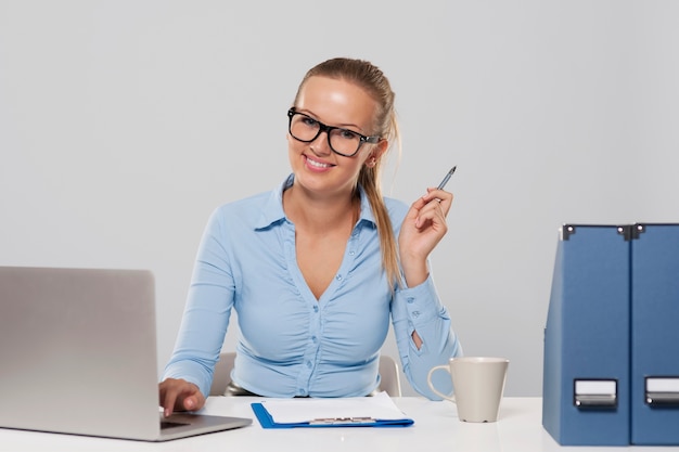 Retrato de mujer sonriente durante el trabajo de oficina