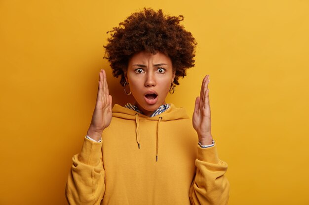 Retrato de mujer sorprendida impresionado hace gesto de gran tamaño