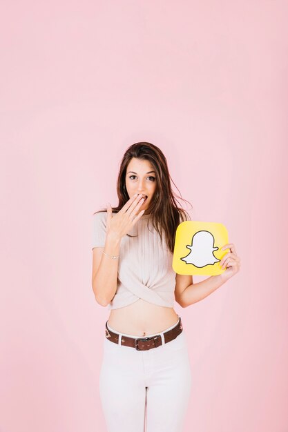 Retrato de una mujer sorprendida sosteniendo el icono de snapchat