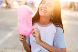 Foto gratuita retrato mujer sosteniendo algodón de azúcar