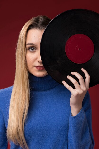 Retrato de una mujer sosteniendo un disco de vinilo