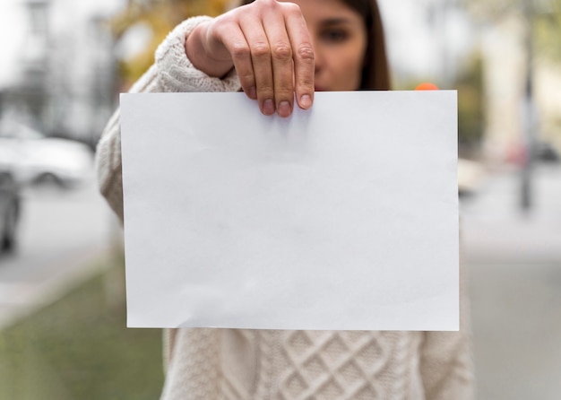 Foto gratuita retrato de una mujer sosteniendo un papel en blanco