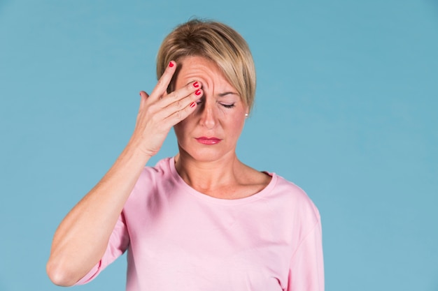 Foto gratuita retrato de una mujer sosteniendo su cabeza en el dolor