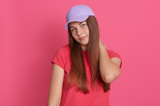 Foto gratuita retrato de mujer sosteniendo su cuello con molestias contra el fondo rosa, mujer con dolor de cuello