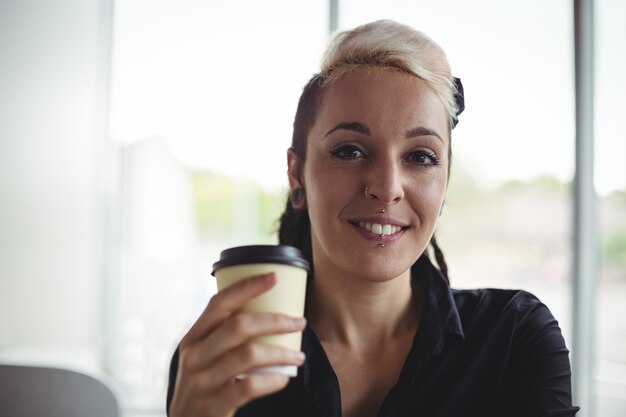 Retrato de mujer sosteniendo la taza de café desechable