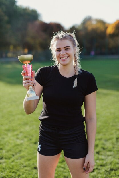 Retrato de mujer sosteniendo un trofeo