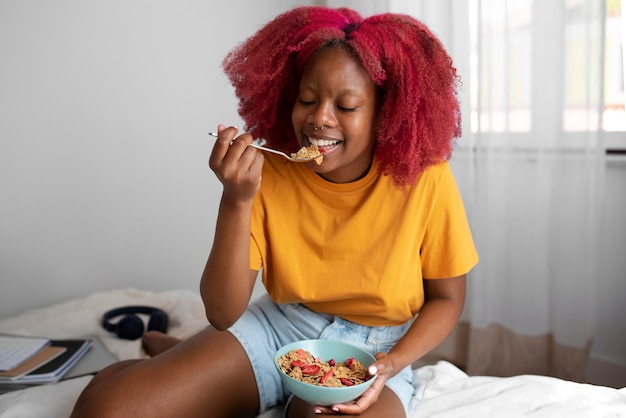 Retrato de mujer sin sujetador en casa desayunando