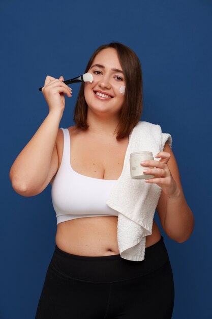 Retrato de mujer de talla grande haciendo su régimen de belleza y rutina de cuidado de la piel