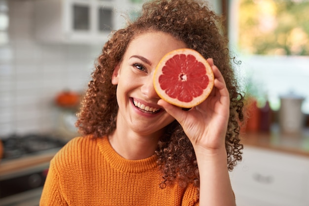 Retrato de mujer tapándose los ojos con pomelo