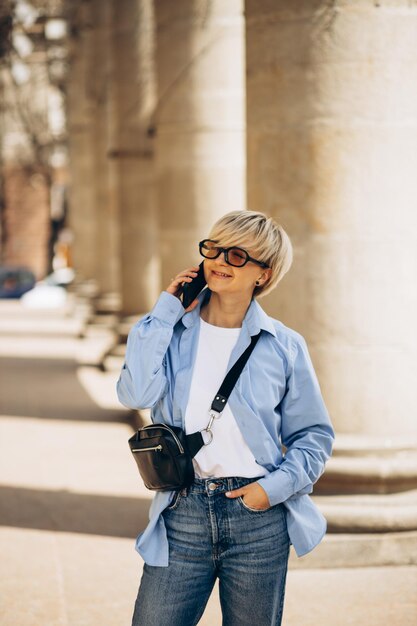 Retrato de mujer con teléfono en la calle