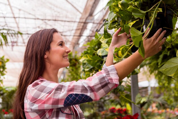 Retrato de mujer tocando plantas en el jardín