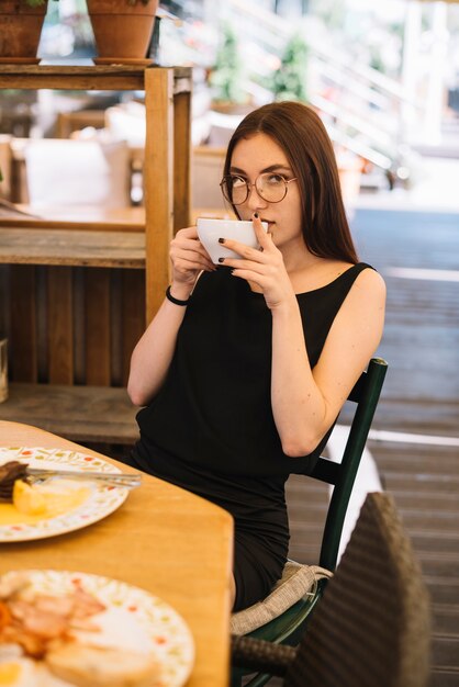 Retrato de mujer tomando café en la cafetería
