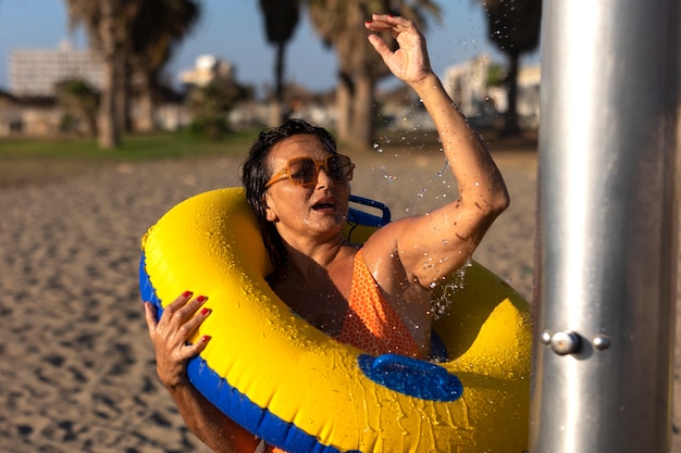 Foto gratuita retrato, de, mujer, tomar, un, ducha, en la playa