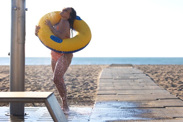 retrato, de, mujer, tomar, un, ducha, en la playa