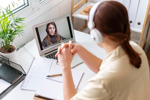 Retrato de mujer en el trabajo con videollamada en portátil