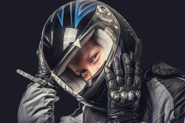 Retrato de mujer con traje de seguridad para motocicletas y casco negro.