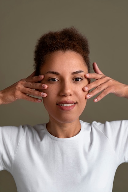 Foto gratuita retrato de mujer tratando de masaje facial de yoga para mantenerse joven