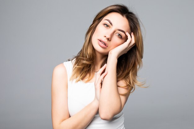 Retrato de mujer triste y molesta en camisa con dolor de cabeza, estrés, problemas, tocar las sienes con los dedos y cerrar los ojos, de pie sobre la pared gris