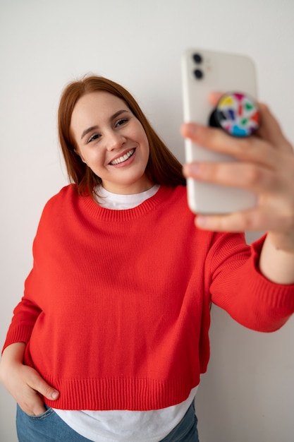 Foto gratuita retrato de mujer usando un teléfono inteligente en casa con toma de corriente