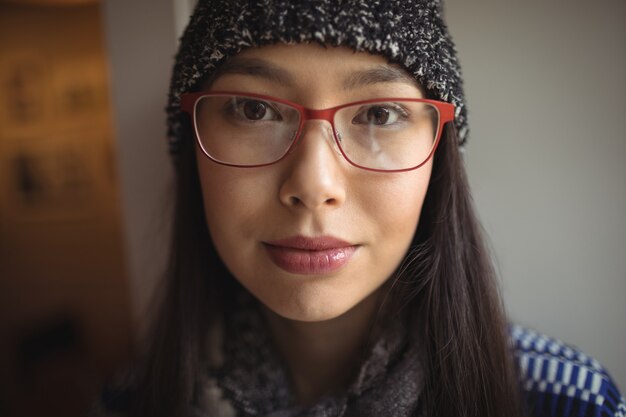 Retrato de mujer vistiendo gorra y gafas en el café