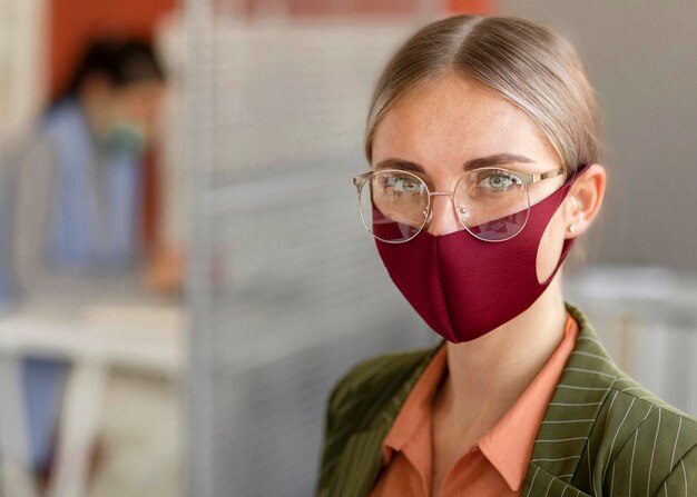 Retrato de mujer vistiendo mascarilla en el trabajo