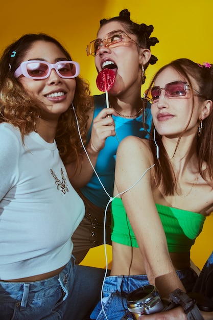 Retrato de mujeres jóvenes en el estilo de moda de la década de 2000 posando con cámara