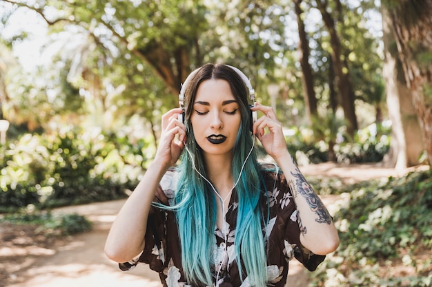 Retrato de una música que escucha de la mujer joven en el auricular