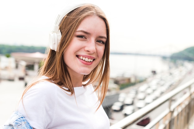 Retrato de la música que escucha sonriente de la mujer joven