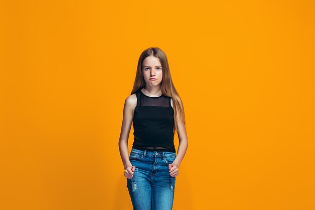 Retrato de niña adolescente enojada en una naranja