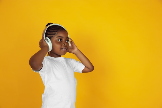 Retrato de niña afroamericana aislado en estudio amarillo