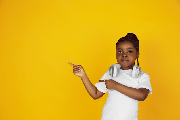 Retrato de niña afroamericana aislado en estudio amarillo