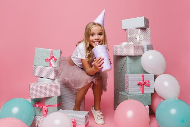 Retrato de una niña alegre en un sombrero de cumpleaños