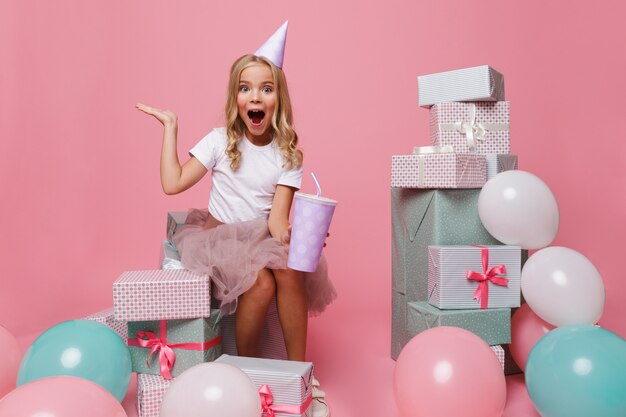 Retrato de una niña alegre en un sombrero de cumpleaños