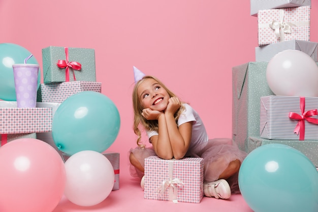 Retrato de una niña alegre en un sombrero de cumpleaños