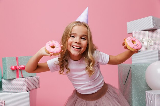 Retrato de una niña alegre en un sombrero de cumpleaños