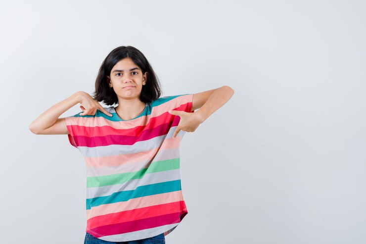 Foto gratuito retrato de niña apuntando a sí misma en camiseta y mirando confiada vista frontal
