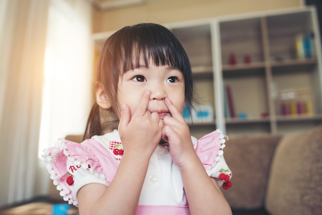 Retrato de niña asiática jugando en su casa