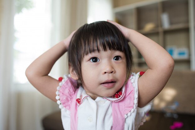 Retrato de niña asiática jugando en su casa