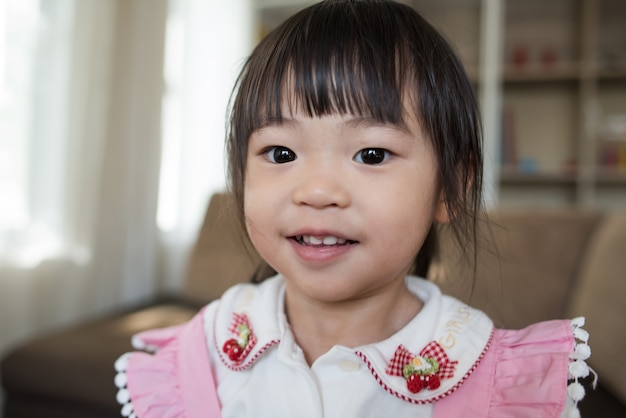 Retrato de niña asiática jugando en su casa