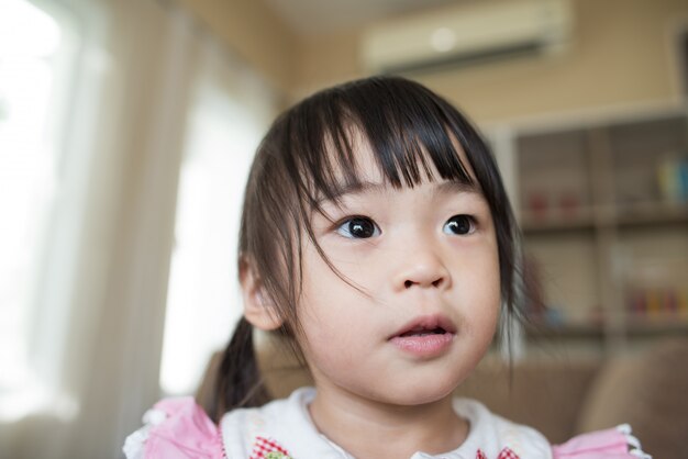 Retrato de niña asiática jugando en su casa