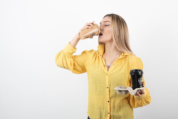 Retrato de niña bebiendo una taza de café en blanco.