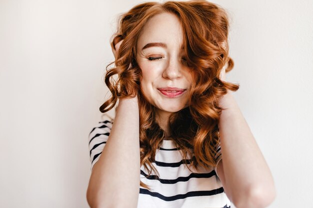 Retrato de niña blanca feliz con hermoso cabello rojo. Modelo femenino de jengibre de ensueño posando con una sonrisa sincera.